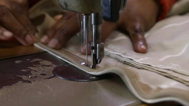 clip of zip being sewn into cushion with electric sewing machine
