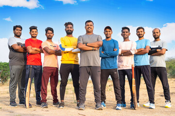 fullshot, group of Confident cricket players standing with arms crossed by looking camera at playground - concept of teamwork, sportsmanship and champions. - Powered by Adobe