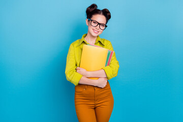 Portrait of cheerful charming lady hold copybooks toothy smile look camera isolated on blue color background - obrazy, fototapety, plakaty
