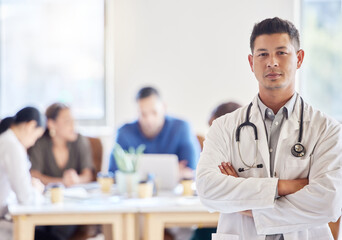 Fototapeta premium Saving lives is my number one priority. Shot of a young male doctor standing with his arms crossed in an office at work.