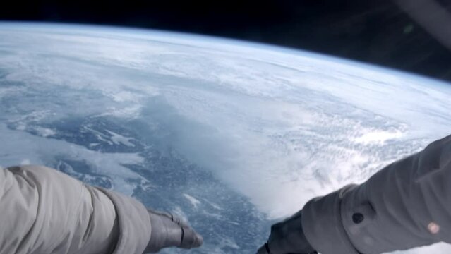 POV First person view through helmet during the spacewalk - astronaut trying to catch something in space