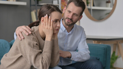 Man Trying to Comfort Upset Female Partner on Sofa 