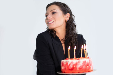 young woman in sexy lingerie and jacket holding birthday cake with candles, birthday concept.