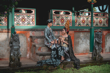 Obraz na płótnie Canvas Balinese teens girl and boy together posing in traditional bali costume in old Hindu temple.