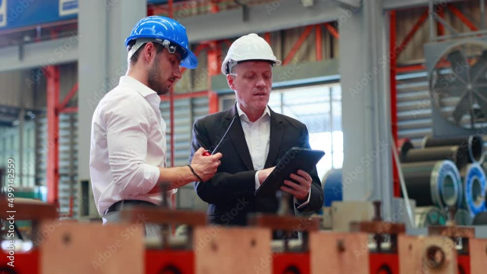 Wall mural lathe and stamping metal machine. Caucasian business man and Factory engineer in hard hat helmet talking and discussion at Heavy Industry Manufacturing Factory.