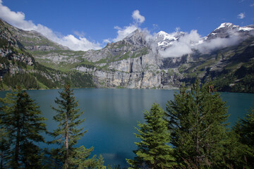 Lake Oeschinen (Oeschinensee) in Switzerland seen from the shore with moutains in the background