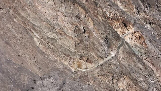 Pakistani trucks travel on dangerous paved road along the mountain, transport goods via Karakoram highway. Gilgit Baltistan, Pakistan.
