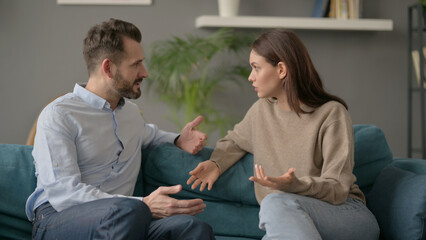 Woman Talking to Man While Sitting on Sofa 