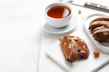 Italian chocolated cantucci with almond and hazelnuts. Biscotti cookies with nuts and cup of tea. Homemade biscotti.