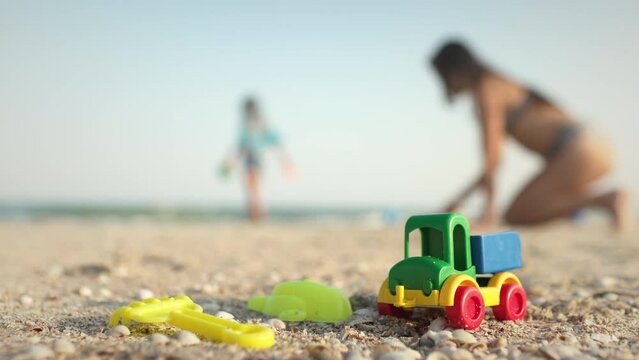 Many toys lie on the beach near the sea under the summer sun