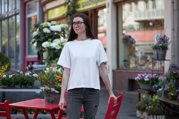 Woman in white blank t-shirt wearing glasses in the city