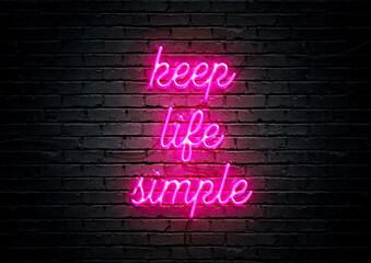 Pink neon sign motivational quote with brick wall background; Keep life simple.