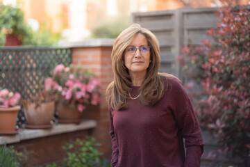 Mature white woman in the garden with flashes of the sun on her back.