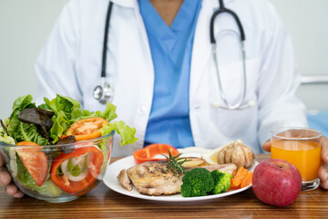 Nutritionist doctor with various healthy fresh vegetables for patient.