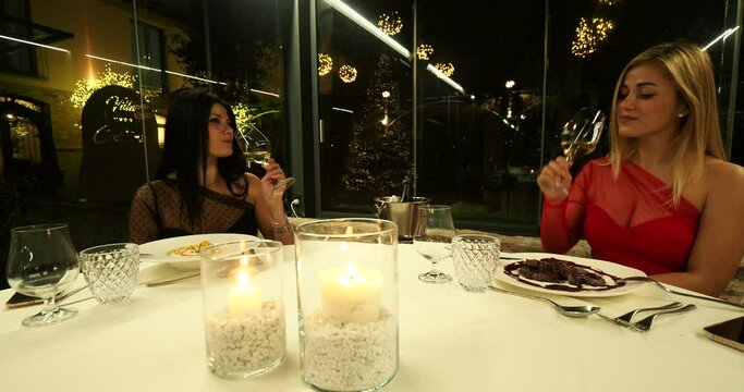 one hispanic woman and oe caucasian dining in a fine restaurant