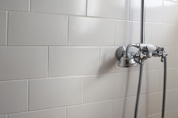 Grifo y ducha sobre racholas blancas, lavabo moderno, neutro y con espacio