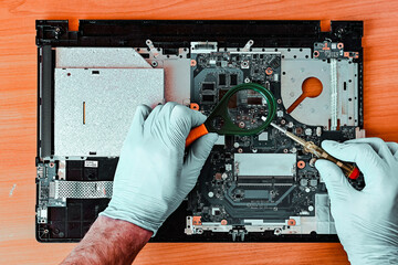 repair and diagnostics of laptop, motherboard repair, PCB, search for problems, man hands in gloves...