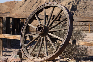 Fototapeta premium Old wagon wheel leaning on a fence