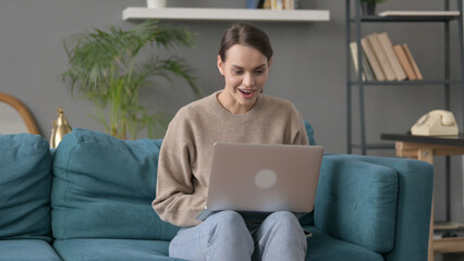 Woman with Laptop Thinking on Sofa 