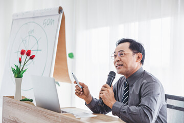 male boss holding a microphone presenting a business in a conference room