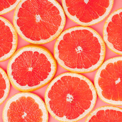 Fototapeta na wymiar Blood grapefruit slices pattern on peach background. Simple square composition.