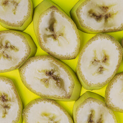 Banana slices pattern on lime green background. Simple square composition.