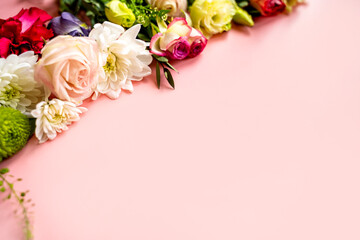 flowers, buds of flowers, roses and chrysanthemums, carnations on a pink background, buds and leaves lie beautifully with a place for text and congratulations