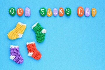 Odd socks day lettering and mismatched colourful socks on blue background. Social school bullying concept. Lost lonely socks. Top view flatlay idea for poster, banner, advertising