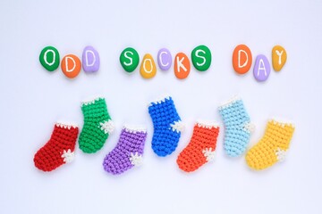 Odd socks day lettering and mismatched colourful socks on blue background. Social school bullying concept. Lost lonely socks. Top view flatlay idea for poster, banner, advertising