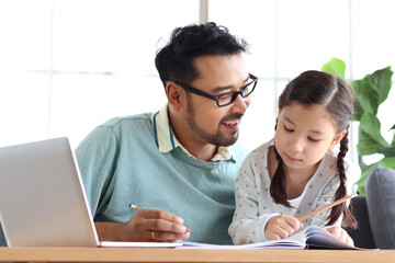 Young handsome father teach adorable girl daughter to do school homework, using laptop computer for e-learning study at home, dad and kid spend time together for education and searching Internet.