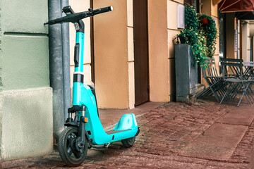 modern technologies in the urban environment. Electric blue scooter parked on a town street to rent it out, concept - eco-friendly city transport