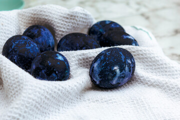 Cosmic-colored eggs lie on a waffle towel. Easter