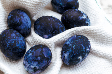 Cosmic-colored eggs lie on a waffle towel. Easter