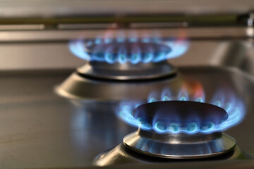 Close up on blue fire from domestic kitchen stove top. Gas cooker with burning flames of propane gas. Industrial resources and economy concept.