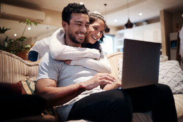 Looks like youre winning, babe. Shot of a man using his laptop while his girlfriend embraces him...