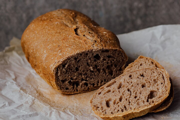 Bread, traditional sourdough bread cut into slices on a rustic wooden background. Concept of traditional leavened bread baking methods. Healthy food.