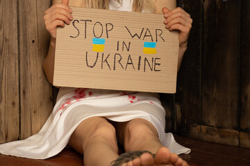 A Ukrainian girl in a white dress with blood stains on her dress, tortured by Russian soldiers in...