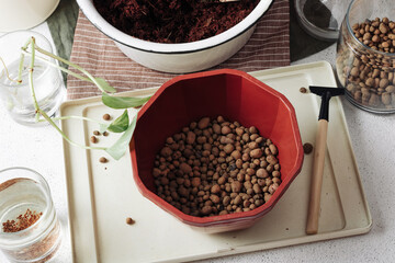 Flower pot with drainage pebbles on a white concrete background