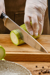 Sliced raw zucchini. Person cutting a zucchini or cucumber. Cooking food. Shallow depth of field