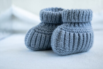 Fototapeta na wymiar Blue knitted socks for newborn babies. Close up. Concept of handmade knitted clothes for babies.