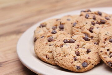 Chocolate cookies are arranged in a light brown dish and are ready to be served to the children.