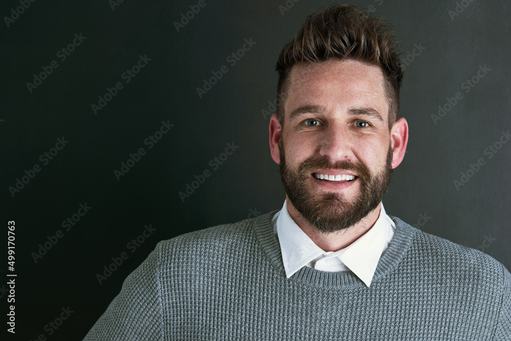 Poster just a friendly face in the studio. portrait of a happy young man posing against a dark background i