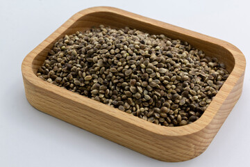 cannabis seeds on a wooden plate on white background, copy space top view horizontal. Banner, cover, mockup, for your design