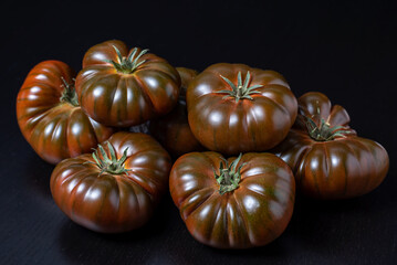 Tomatoes of the black Raf variety on a black background