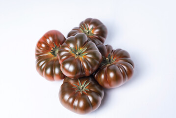 Tomatoes of the black Raf variety on a white background