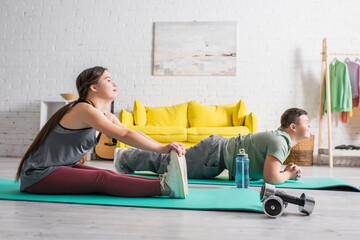 Side view of teenagers with down syndrome training on fitness mats at home.