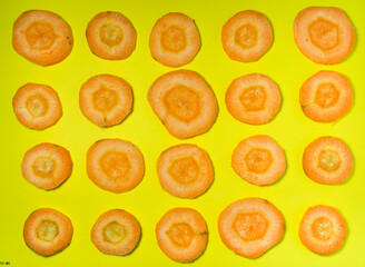 cut carrot on a yellow background. Background of carrot slices. Vegetarian food. Vitamins. Fresh vegetables on the table.