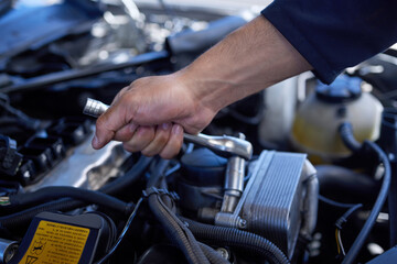 Safety first. High angle shot of an unrecognizable male mechanic working on the engine of a car during a service.