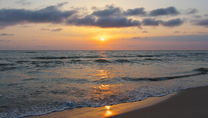  Bright beautiful sunset at the calm sea. Solar disk over water.