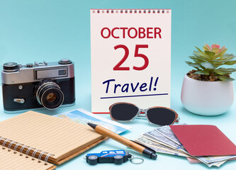 Travel planning, vacation trip - Calendar with the date 25 October glasses notepad pen camera cash passports.